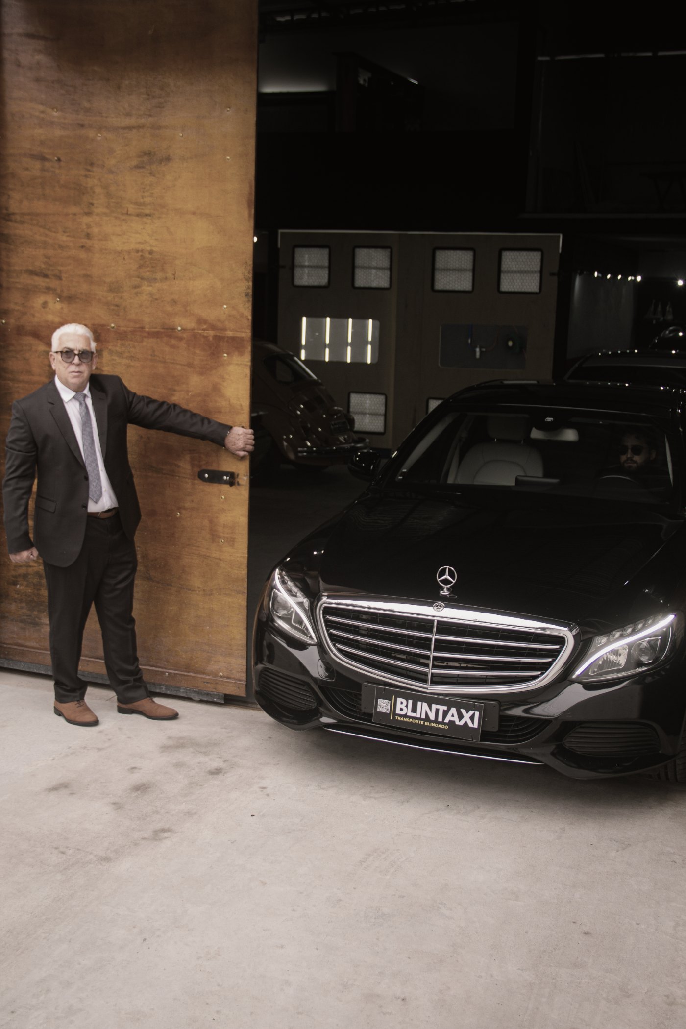 Blintaxi chauffeur beside the armored vehicle, airport service